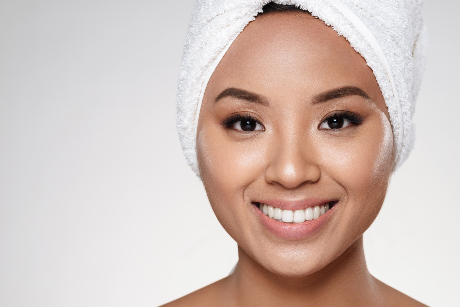 attractive-lady-without-make-up-with-towel-head-smiling-camera